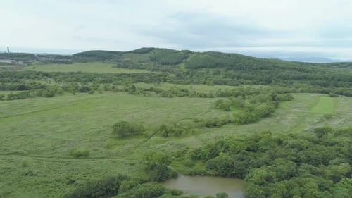 Aerial Drone View Beautiful Natural Scenery of Green Meadow with River Mountains in Background