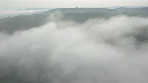 Dense Clouds Canopy Over Foggy Forest Mountains. Aerial Shot