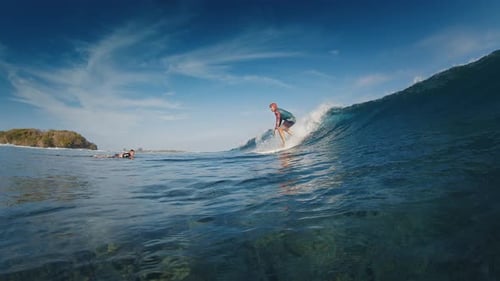 Surfer Rides the Ocean Wave in the Maldives In Water and Underwater View of the Surfer on the Wave