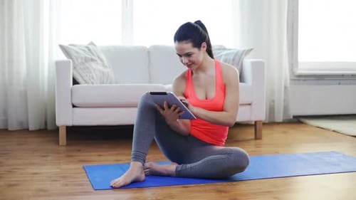 Woman Using Tablet on Yoga Mat at Home