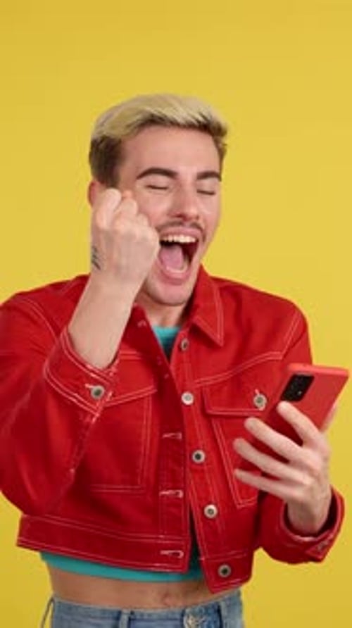 Excited Gay Man Celebrating While Using the Mobile Phone
