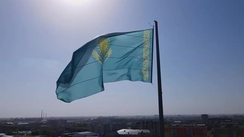 Kazakhstan National Flag Waving over Cityscape