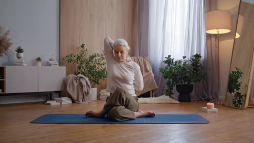 Senior Woman Practicing Yoga at Home on Mat