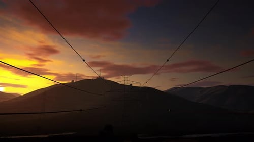 High Voltage Electricity Tower On Mountains At Sunset. 4K Time Lapse Of Sunset