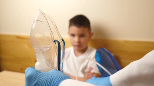 27 cm. Le garçon se prépare pour la procédure d'inhalation par nébuliseur. Ralenti.