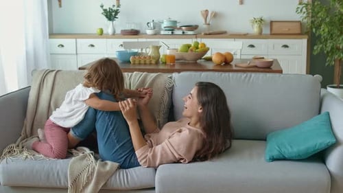 Mother and Child Play on Couch Together