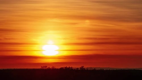 Fantastischer Sonnenuntergang über dem Horizont am orangefarbenen Himmel mit weichen Wolken Zeitraffer