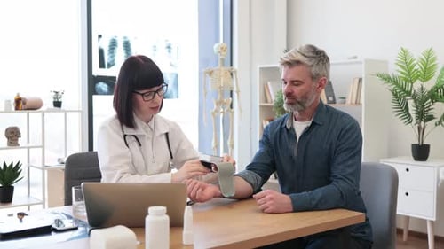 Doctor Taking Patient's Blood Pressure in Office
