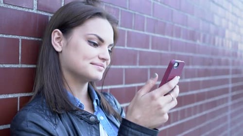 Young Beautiful Caucasian Woman Using Smart Phone in the City