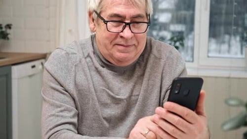 Mature Man Using Smartphone at Home