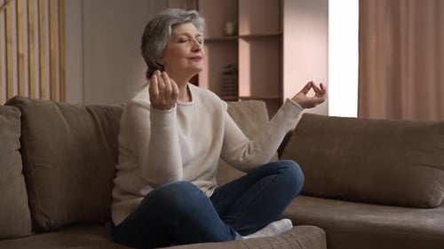 Mature Woman Meditating on Couch