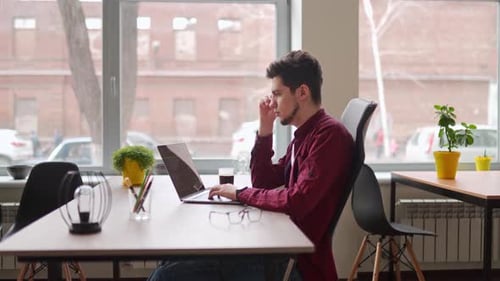 Man Works on Laptop in Bright Office