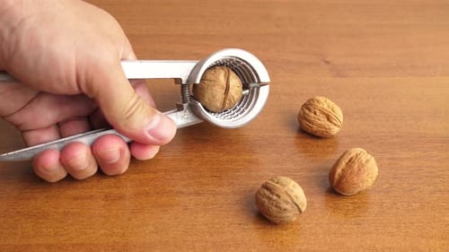 78s. Walnuts are split with a nutcracker. Kitchen appliances for work in the kitchen.