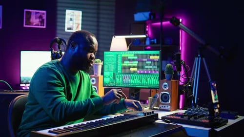 Young Adult Creates Music on Keyboard in Studio