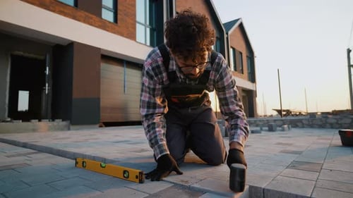 Man Laying Brick Pavers on Suburban Home Patio