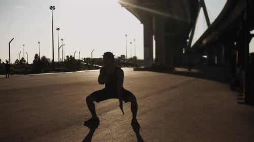Sportlicher muskulöser junger Mann beim Training unter der Brücke