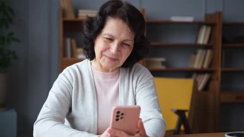 Woman Smiling Using Cellular Phone Indoors at Home