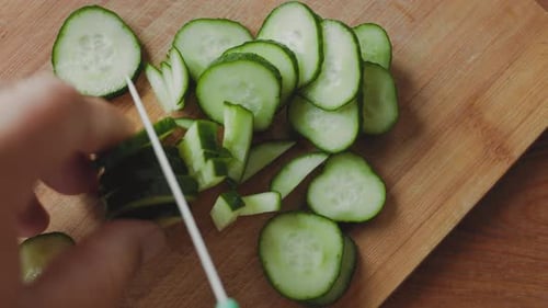 Close Up Chopping Cucumber on Cutting Board