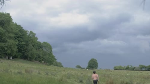 Shirtless Man Running Freely in a Beautiful Green Field