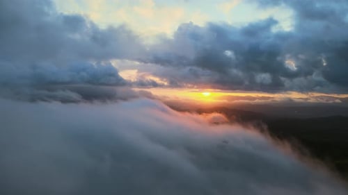 Aerial View of Sunrise Through Thick Clouds