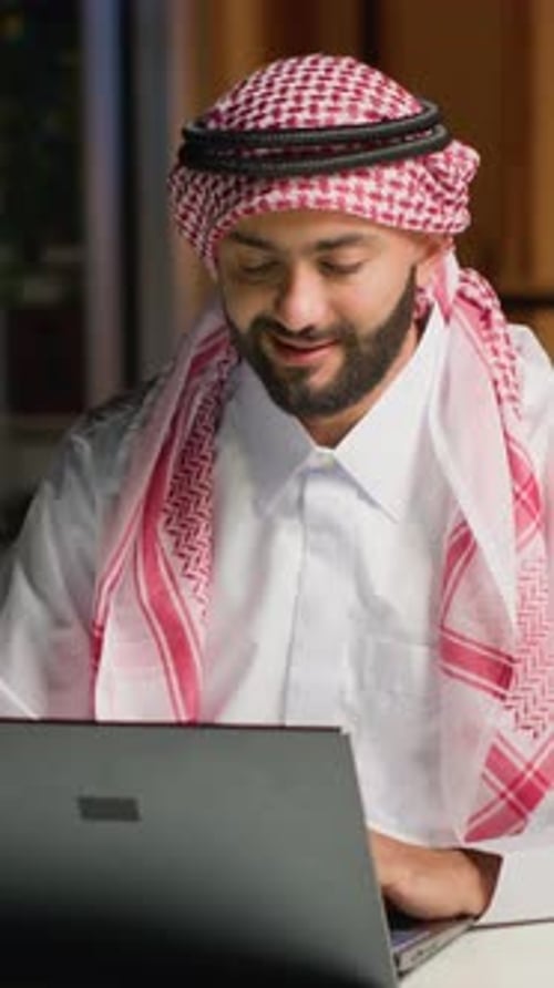 Man Works On Laptop in Office Setting