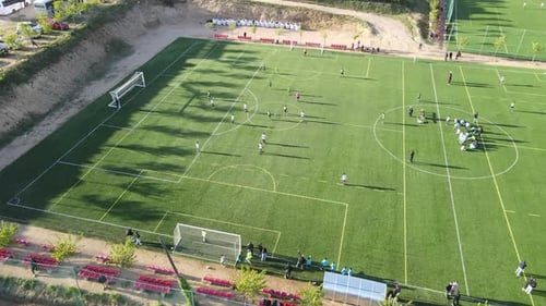 Aerial View of a Soccer Game on Green Field