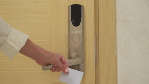 Woman Opens Hotel Room Applying Key Card to Electronic Lock
