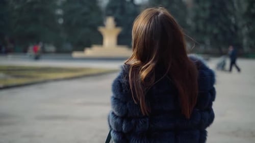 Portrait of a smiling girl in fur coat outdoors.