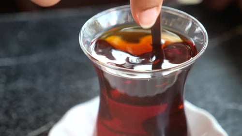 a Hand Stirring Turkish Tea in a Traditional Glass