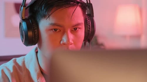 Asian Gamer Playing on Computer at Home