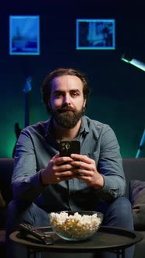 Vertical Video Man Relaxing on Couch at Home Texting Friends on Smartphone