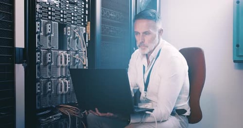 Gesicht eines reifen Mannes im Serverraum mit Laptop, Netzwerkwartung und Ingenieur für digitalen Speicher