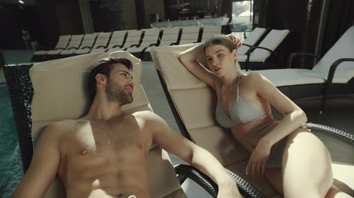 Close Up Romantic Couple in Swimwear Talking on Loungers Poolside. Beautiful Man