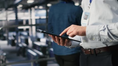 Close Up of Server Room Worker Checking Code on Tablet Next to Colleague