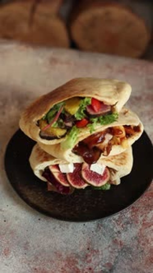pitas with different fillings on a black plate in a restaurant