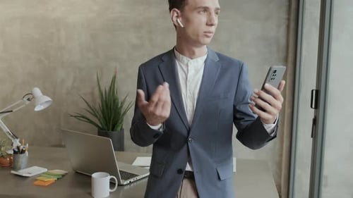 Young Adult in Suit Using Cellphone for Video Call