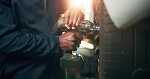 Mechanic, drill and service for tire, hands and maintenance of car in garage