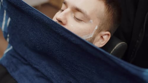 Man Relaxing with Towel at the Barber Shop