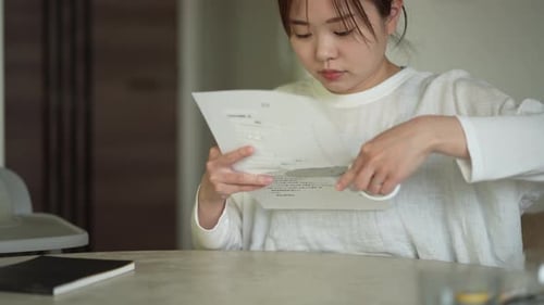 Woman Cutting and Folding Paper Indoors