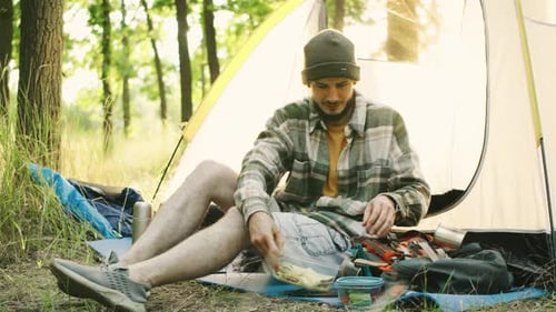 Man Eats Healthy Lunch While Camping in Forest