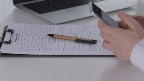 Hands Using Mobile Smartphone Apps While Working on Laptop Indoors Room Office