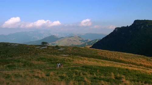 A group of active healthy sport people hiking on mountain top in the alps mountains on panoramic Mon