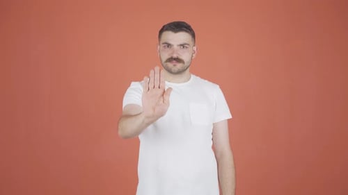 Mann macht Stoppschild für die Kamera.