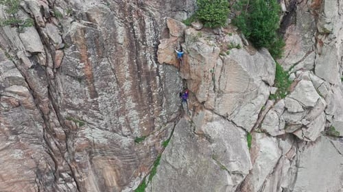 Two Climbers are Making Their Way Up a Steep Rock Face