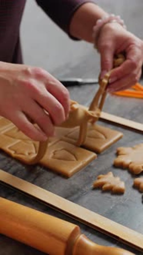 Close Up Woman Hands Removing Cut Dough Shape Using Cutter with Baking Tools Nearby