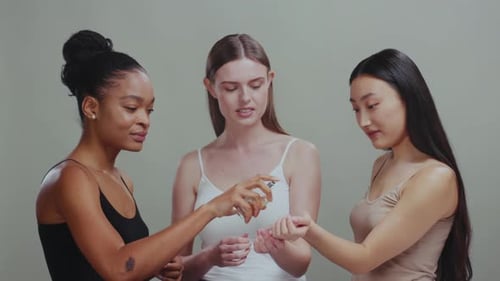 Three Women Test and Enjoy Perfume Together Indoors