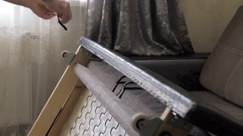 Um homem mede o comprimento com uma fita métrica de um sofá no fundo de um conjunto de ferramentas
