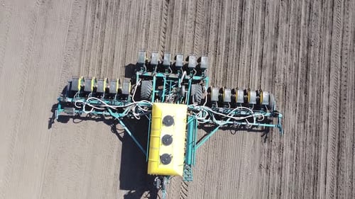 Tracteur avec semoir jaune travaillant sur le terrain en Ukraine OA Lexa