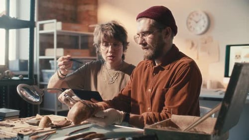 Two Researchers Examining Ancient Skull in Archaeology Laboratory