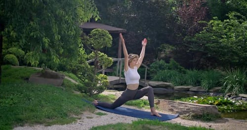 Caucasian Beautiful Sporty Slim Young Woman Doing Yoga Physical Training Outdoors in the Park
